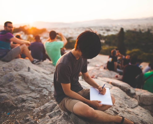 group of people on rock writing sunset scenery