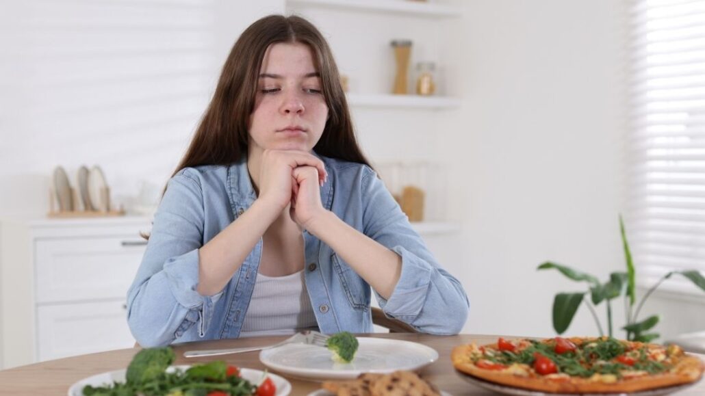 Girl sitting at table not eating food